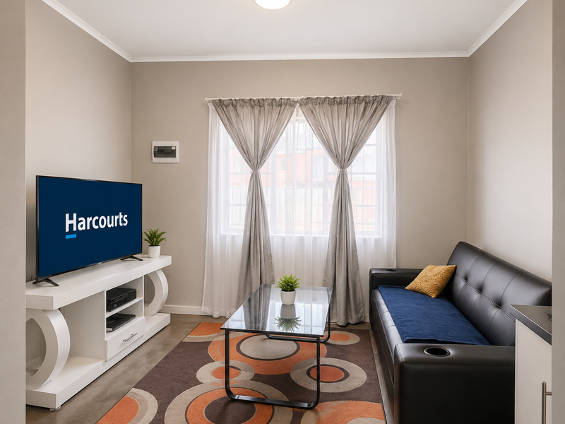 A well-maintained living room featuring neutral wall tones, a large window with curtains, and an integrated electrical distribution board.