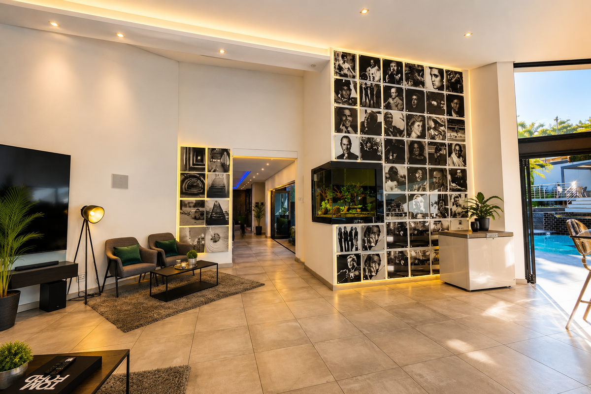 Modern open-plan living area featuring large format floor tiles, recessed lighting, a built-in aquarium, and seamless indoor-outdoor flow through bi-fold glass doors.