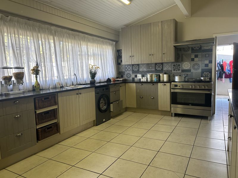 A functional kitchen featuring built-in cabinetry, granite countertops, a stainless steel oven with extractor fan, and decorative tiled backsplash.