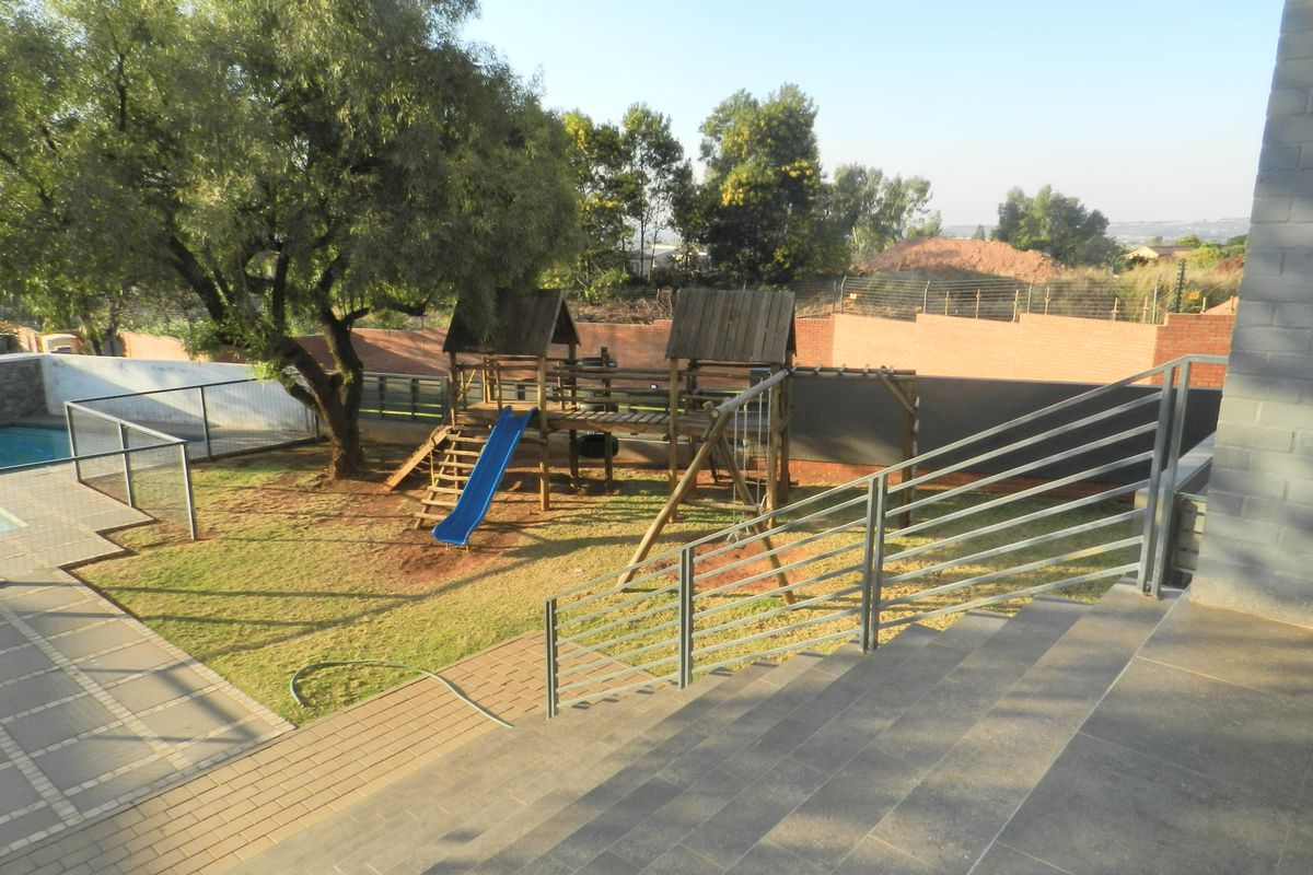 Rear garden area featuring a swimming pool, paved patio, and a staircase leading down from the main dwelling.