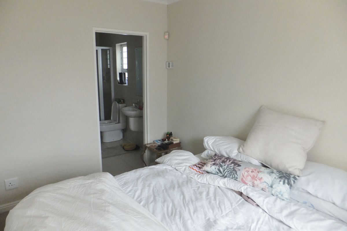 A bedroom featuring neutral walls and an en-suite bathroom with a toilet and basin.