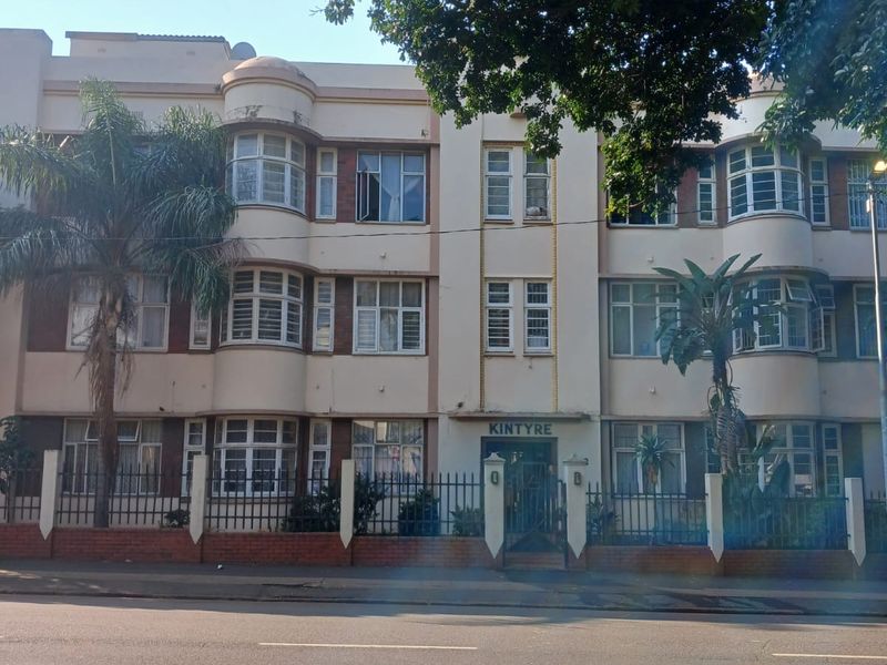 Front elevation of the Kintyre apartment building featuring classic architectural bay windows, a secure gated entrance, and established perimeter landscaping.