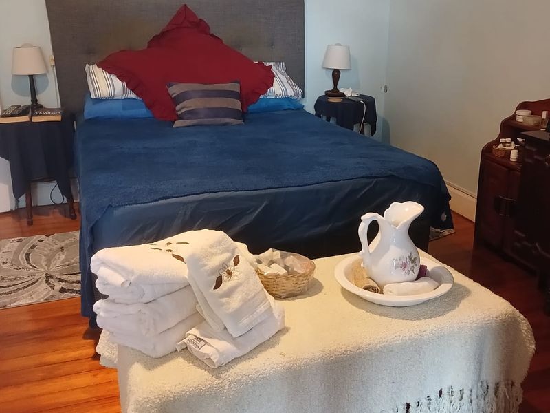 A bedroom featuring polished hardwood flooring and crown molding, providing a classic foundation for interior updates.