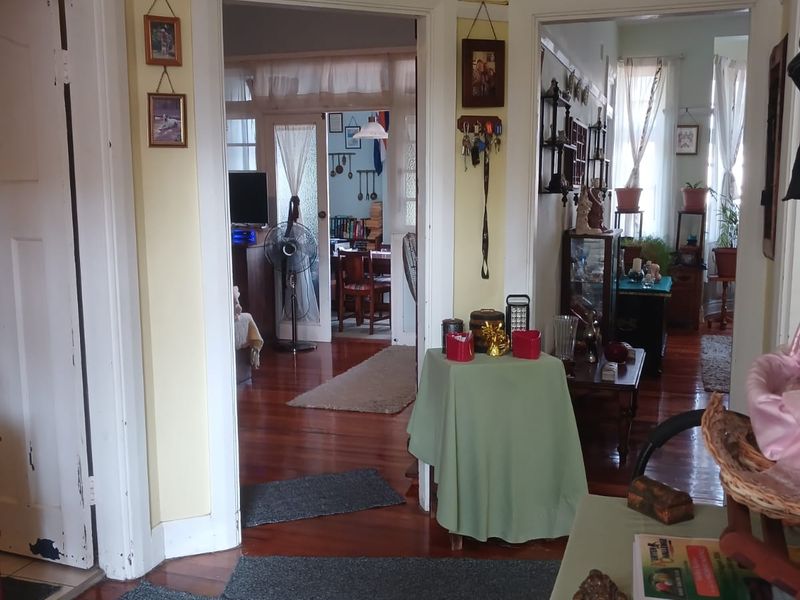 A central hallway featuring original hardwood flooring and traditional architraves, providing access to multiple living areas within the apartment.