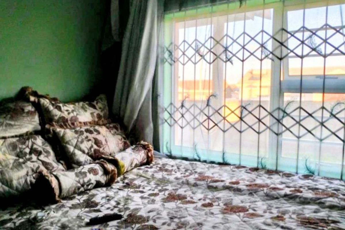 A bedroom featuring a window with an integrated security gate, providing natural light and security.