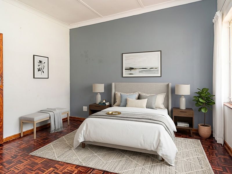 A bedroom featuring classic parquet flooring, a coved ceiling, and a blue feature wall with security bars on the window.