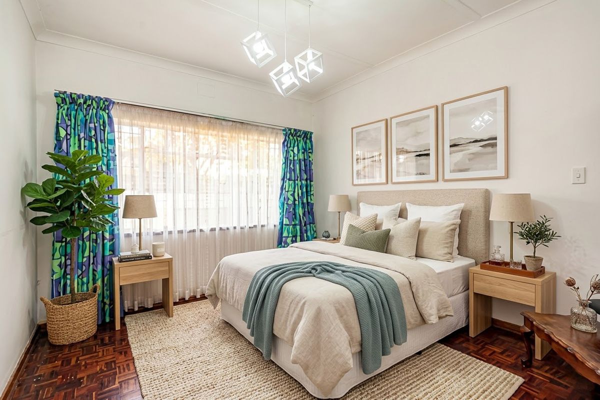 A well-maintained bedroom featuring classic parquet flooring, coved ceilings, and a large window with natural light.