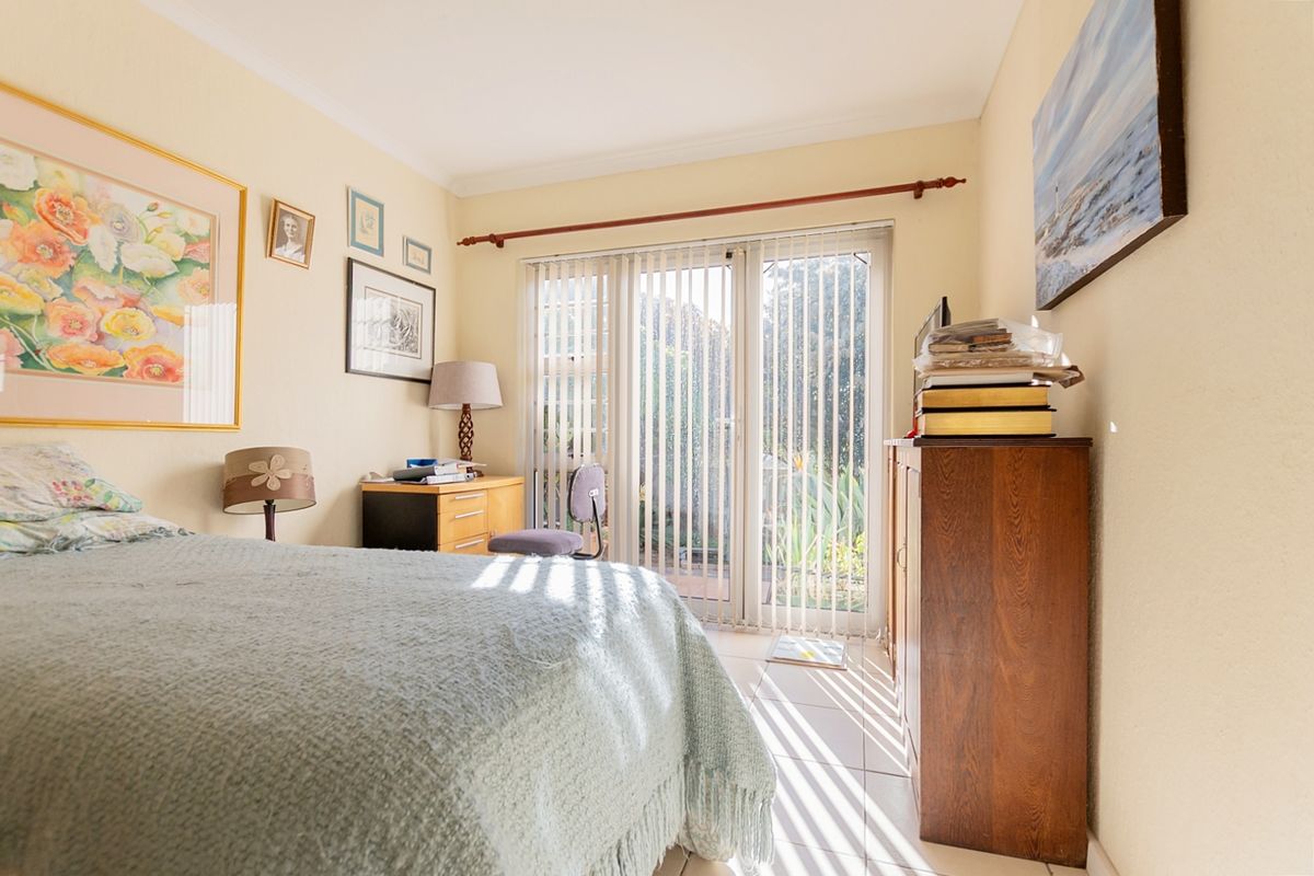 A bedroom featuring tiled flooring and sliding glass doors that provide direct access to the outdoor area.