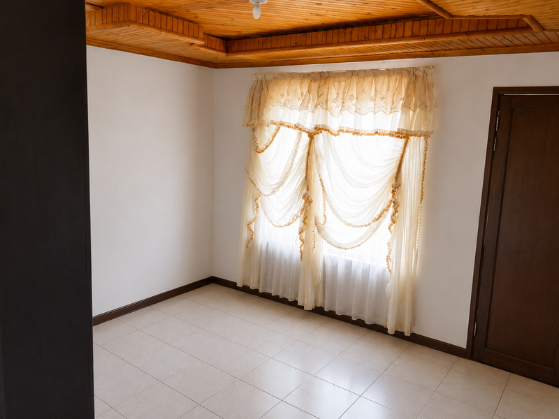 An empty bedroom featuring a timber tongue and groove ceiling, neutral ceramic floor tiles, and a solid wood door.