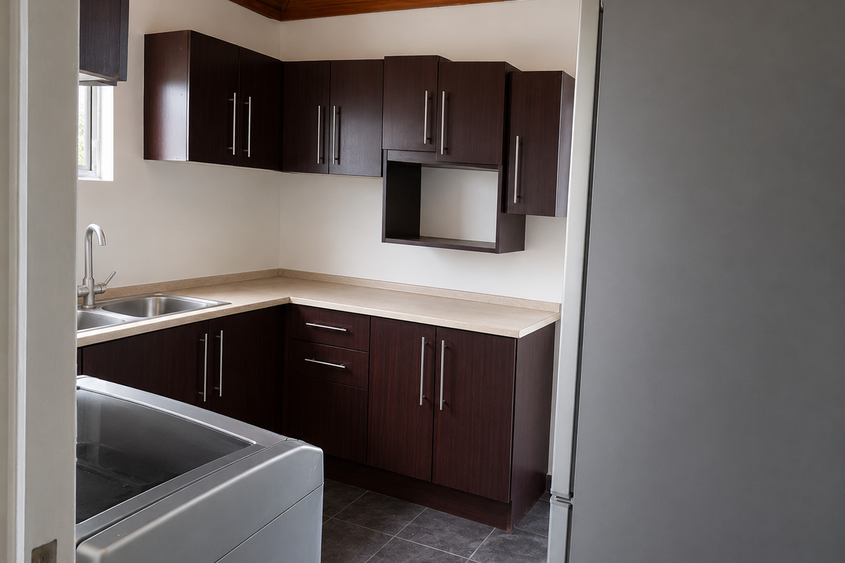 A functional kitchen featuring dark wood cabinetry, laminate countertops, a stainless steel sink, and a timber ceiling.
