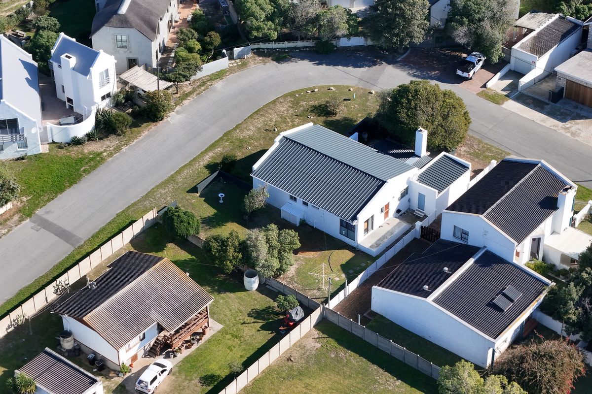 Aerial view of the property showing the house layout, roof structure, and surrounding garden area within the residential estate.