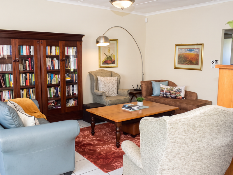 A comfortable living room featuring tiled flooring and a built-in wooden bookshelf, providing a cozy and functional space for relaxation.