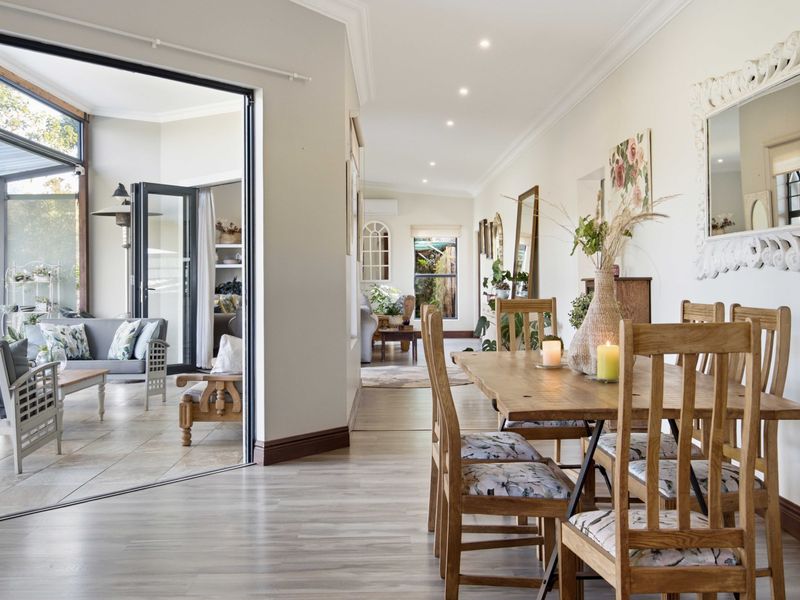Bright open-plan living and dining area featuring seamless indoor-outdoor flow through large sliding glass doors to a covered patio.