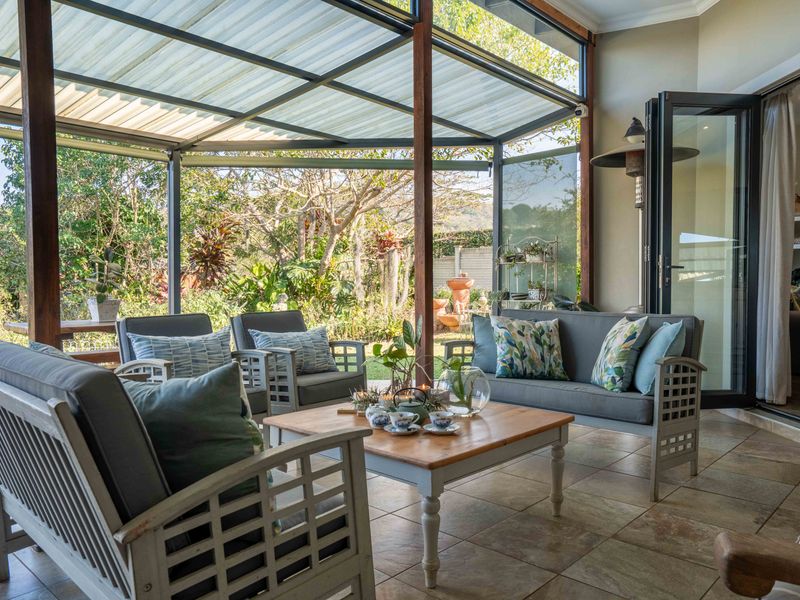 A covered outdoor patio featuring tiled flooring, timber structural supports, and bi-fold doors providing seamless access to the interior living space.