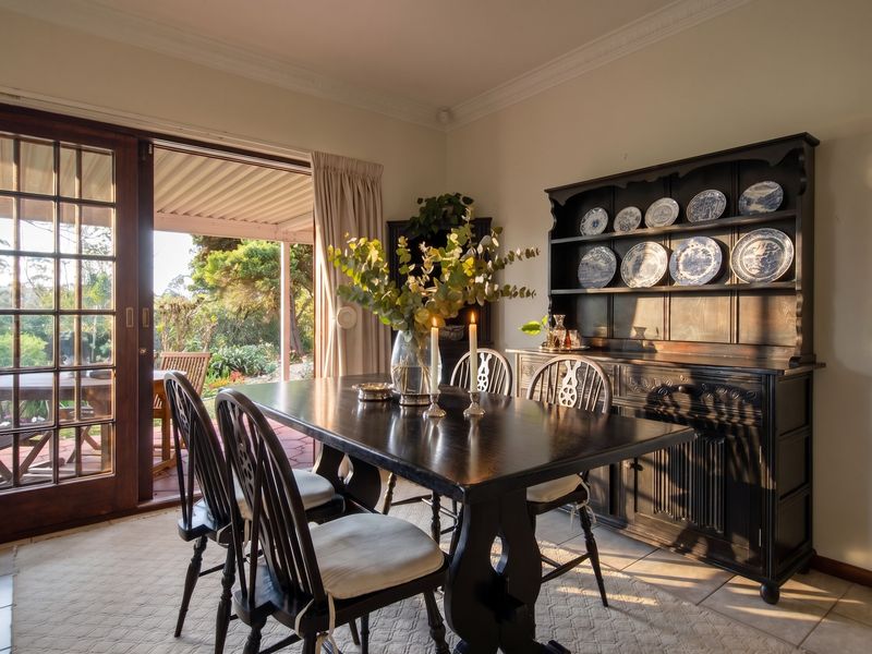 A well-lit dining room featuring tiled floors, crown molding, and a large sliding glass door providing direct access to the outdoor patio area.