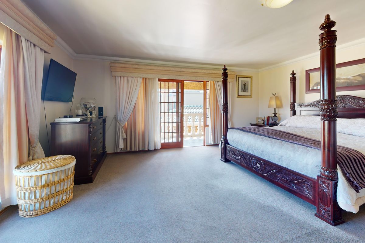 Spacious bedroom featuring carpet flooring, large windows, and direct access to a private balcony through sliding glass doors.