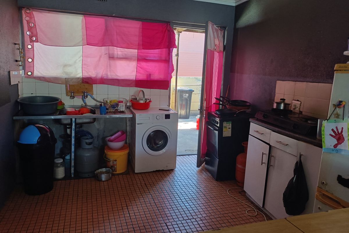 A functional kitchen area featuring tiled flooring, built-in cabinetry, a gas stove, and direct access to the exterior.