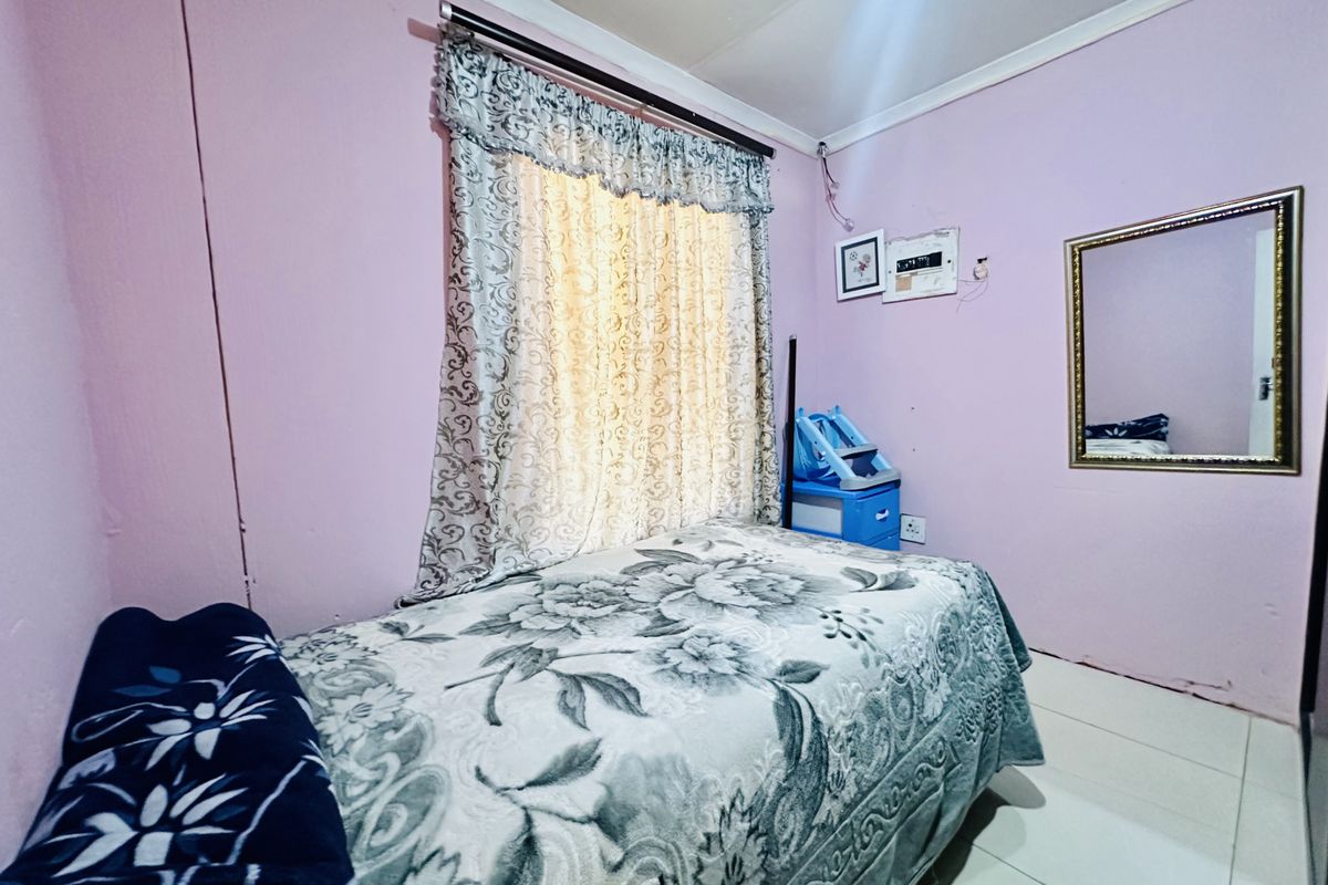 A bedroom featuring tiled flooring and an exposed electrical distribution board, requiring cosmetic updates to improve the overall finish.