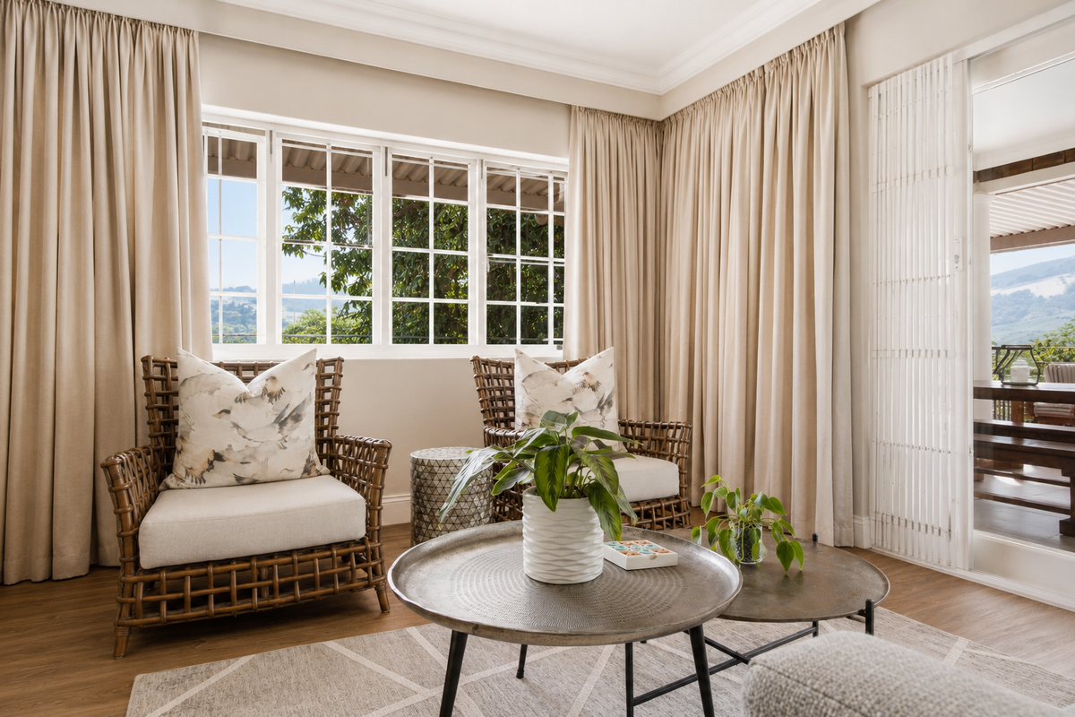 A bright and inviting living area featuring large multi-pane windows, crown molding, and seamless access to an outdoor patio through sliding glass doors.