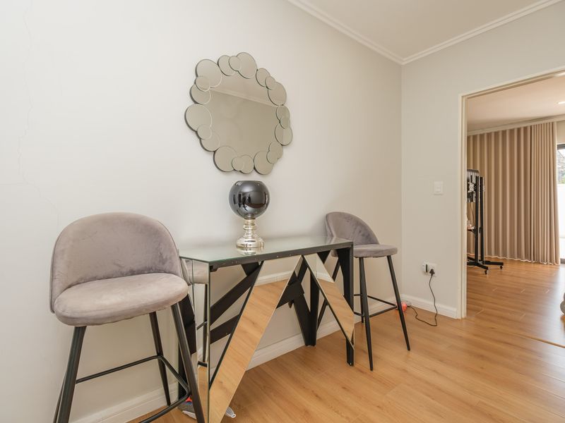 A bright hallway featuring laminate flooring and coved ceilings, providing a clean transition between living spaces.