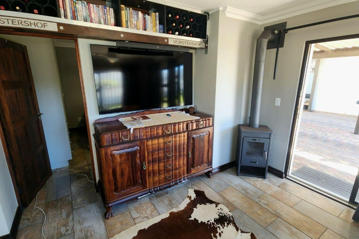 Living room featuring tiled flooring, a freestanding fireplace, and direct access to an outdoor patio area through a sliding glass door.