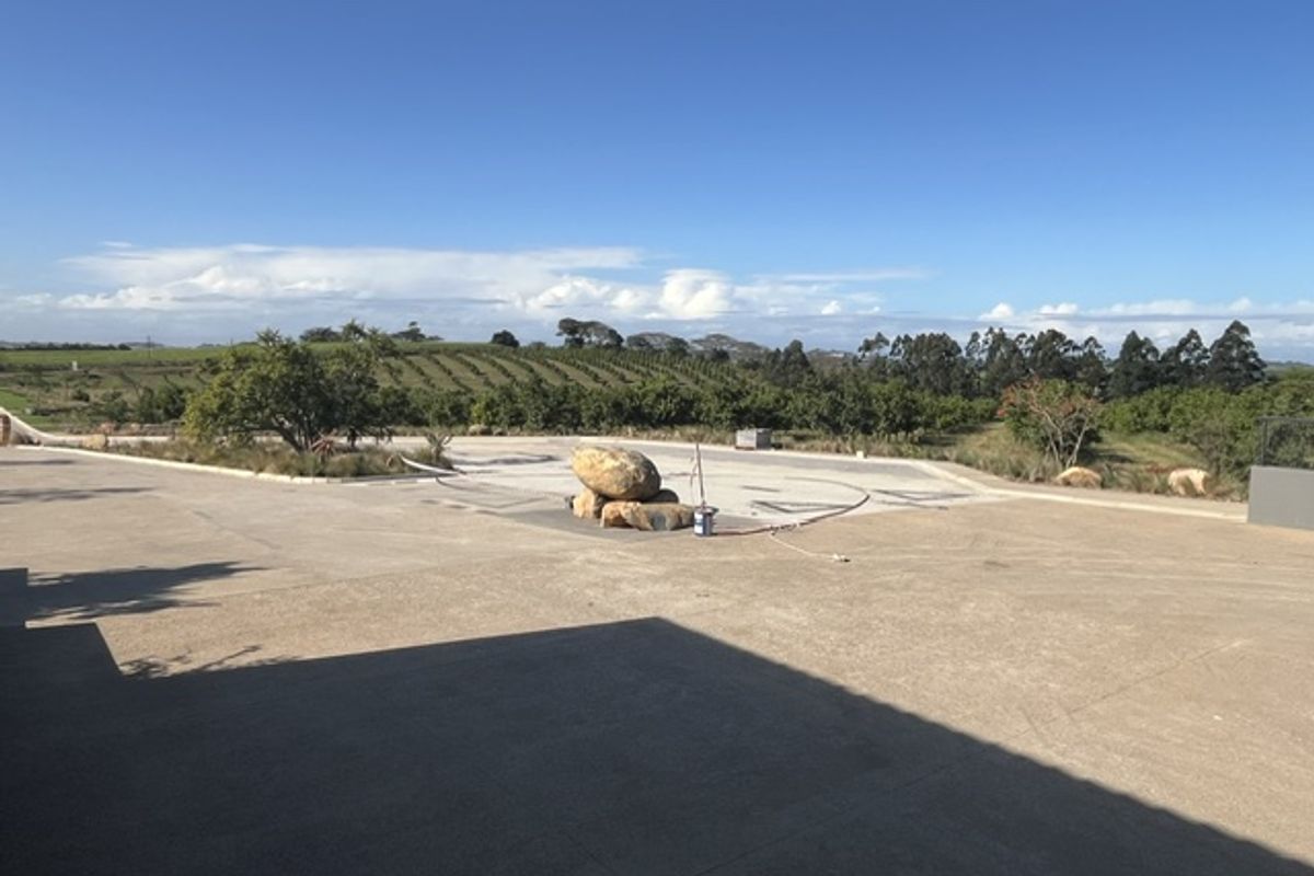 A spacious paved outdoor area overlooking a scenic orchard and rolling landscape, offering a peaceful and open setting.