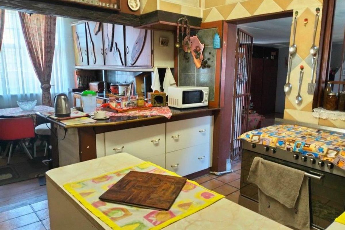 A dated kitchen featuring built-in cabinetry, a central island, and a freestanding oven, offering significant potential for a modern renovation.