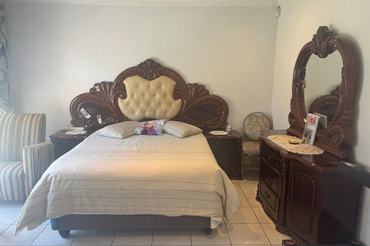 A bedroom featuring tiled flooring and decorative ceiling cornicing, providing a neutral foundation for potential interior updates.
