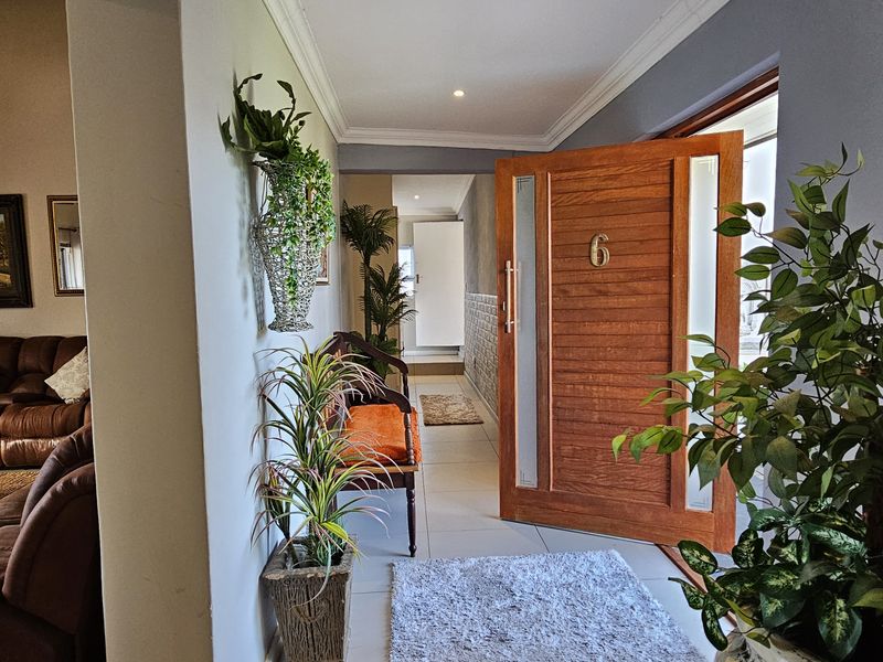 Welcoming entrance hall featuring a solid timber front door and neutral tiled flooring, leading into the main living area.