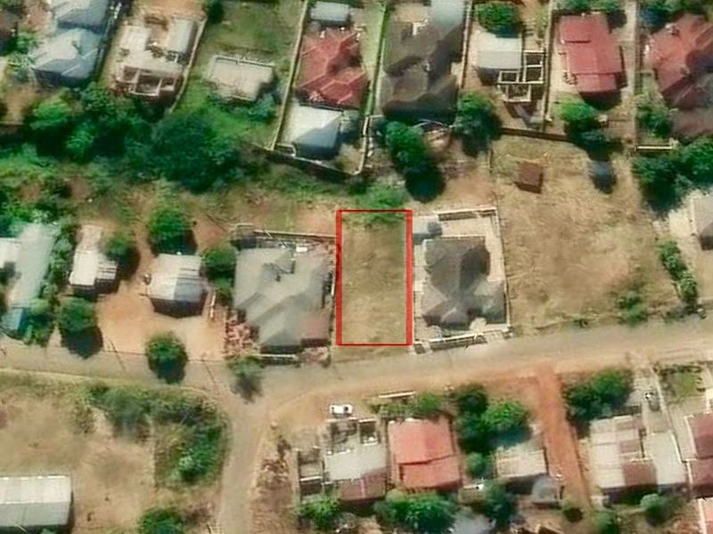 An aerial view showing a vacant residential land plot highlighted in red, situated within an established suburban neighborhood.
