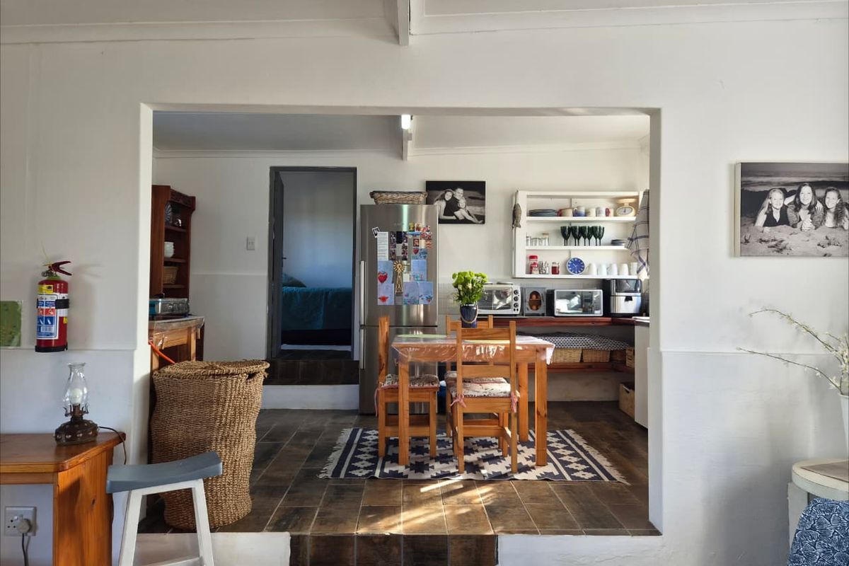 A functional kitchen area featuring tiled flooring and built-in shelving, accessible via a small step from the adjacent living space.