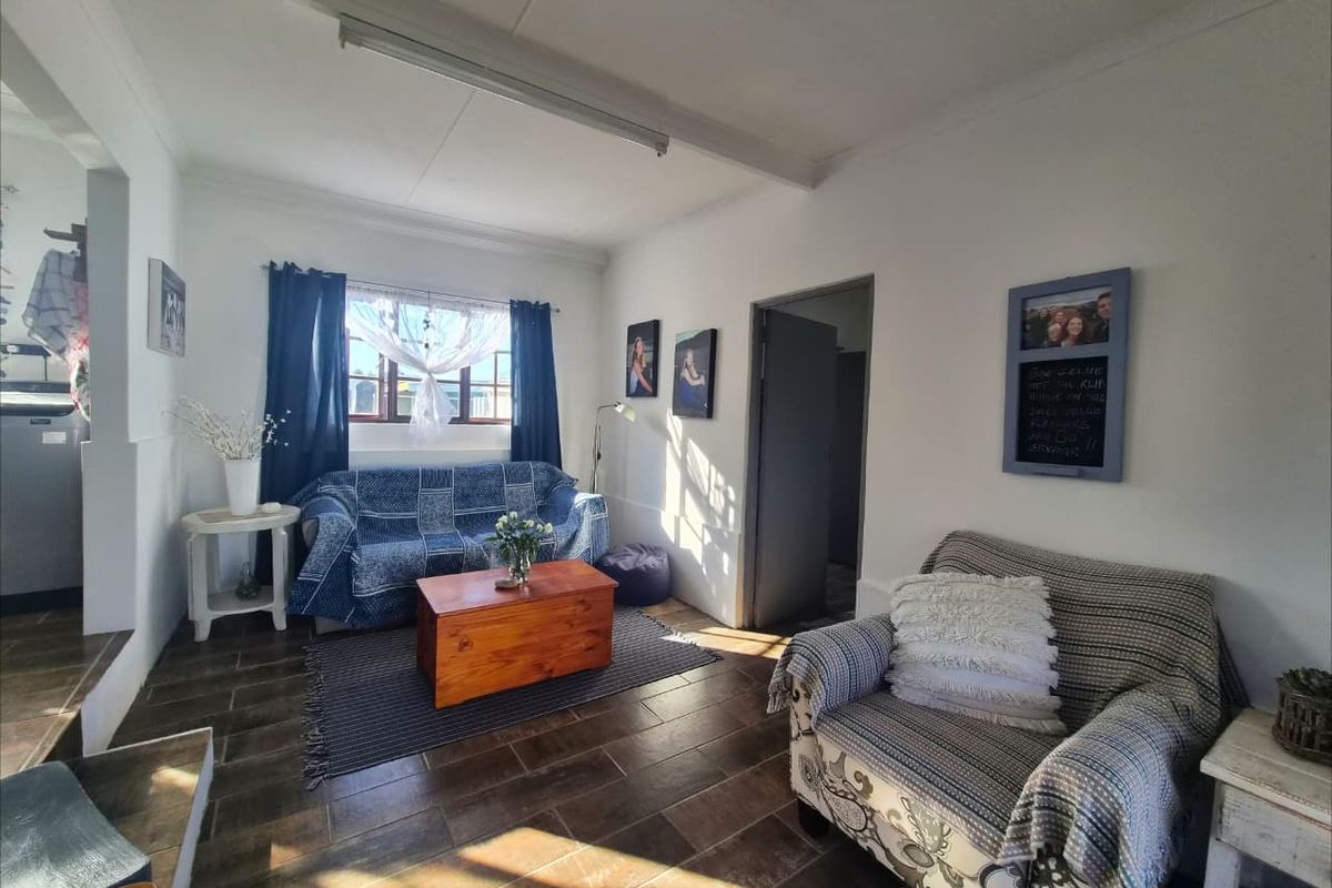 A living room featuring tiled flooring and natural light, providing a functional and comfortable space for relaxation.