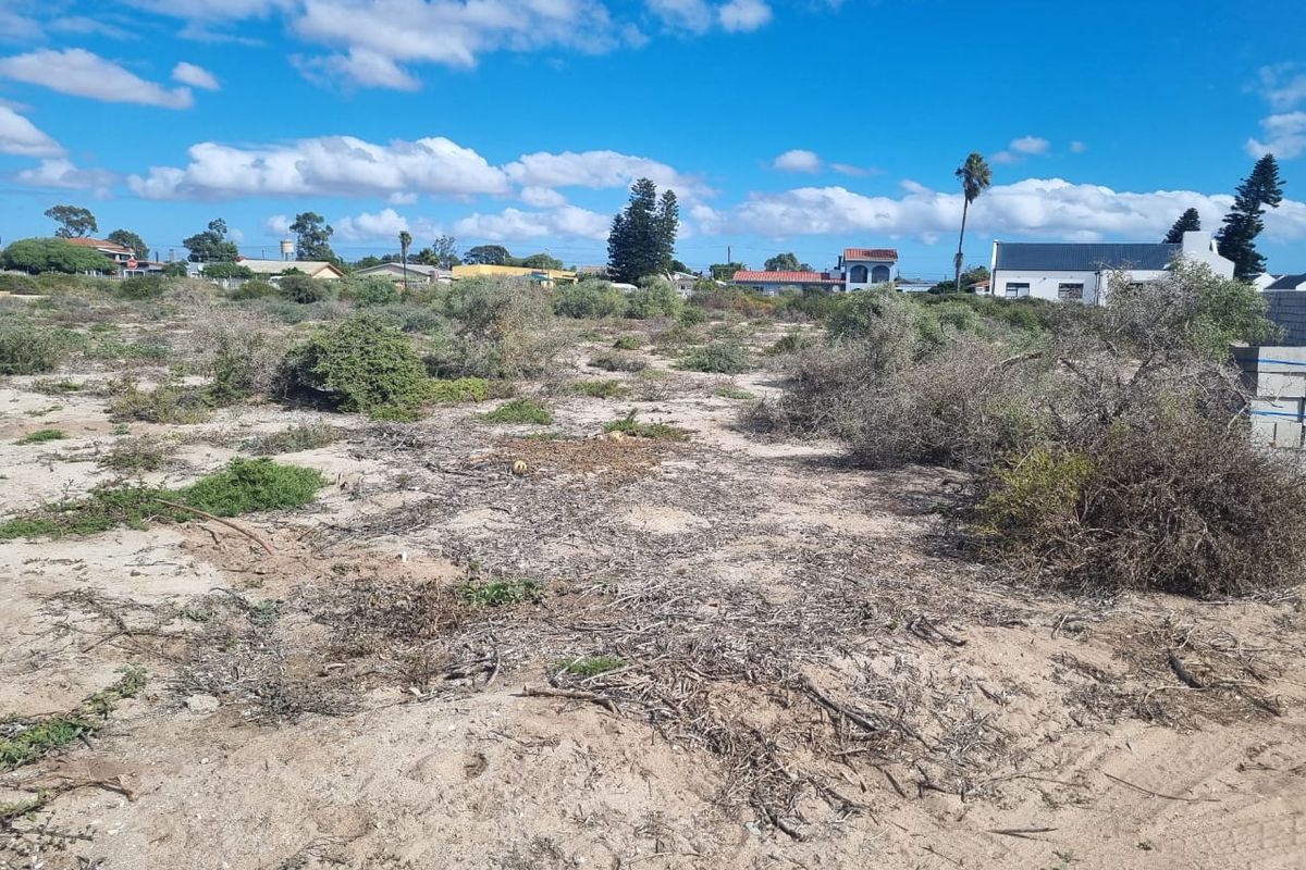 An undeveloped plot of land featuring natural sandy terrain and wild shrubbery, offering a blank canvas for future landscaping or construction projects.