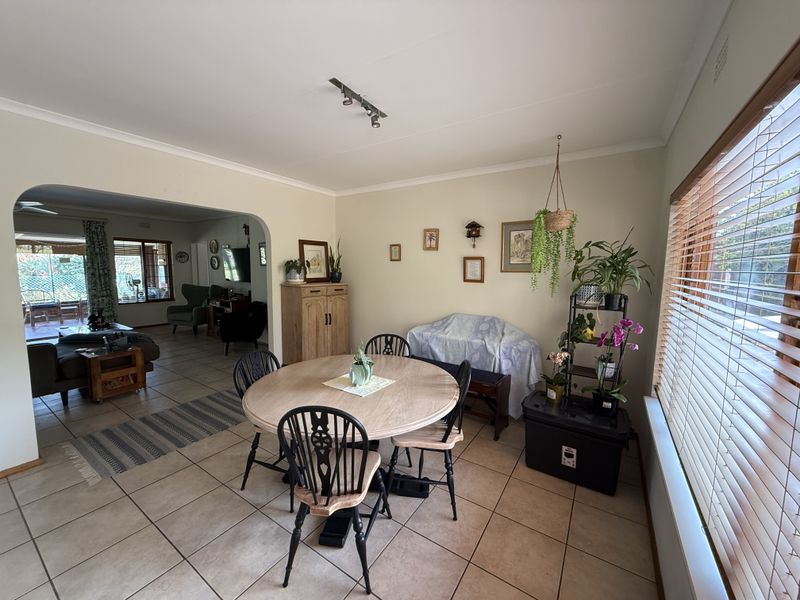Open plan dining area featuring tiled flooring, track lighting, and an arched transition leading into the adjacent living space.
