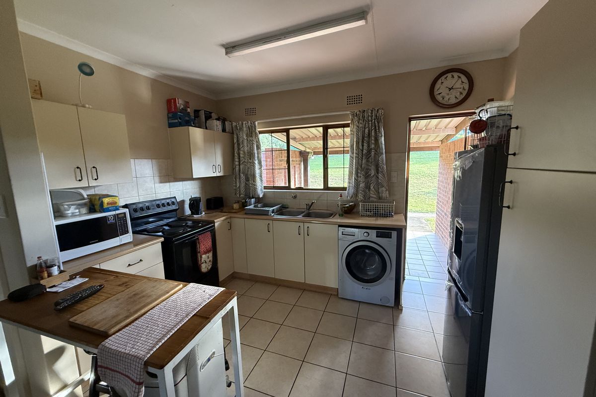 Functional kitchen featuring built-in cabinetry, tiled flooring, and direct access to an outdoor patio area.