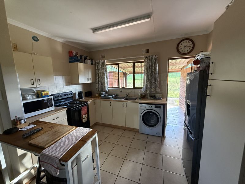 Functional kitchen featuring built-in cabinetry, tiled flooring, and direct access to an outdoor patio area.