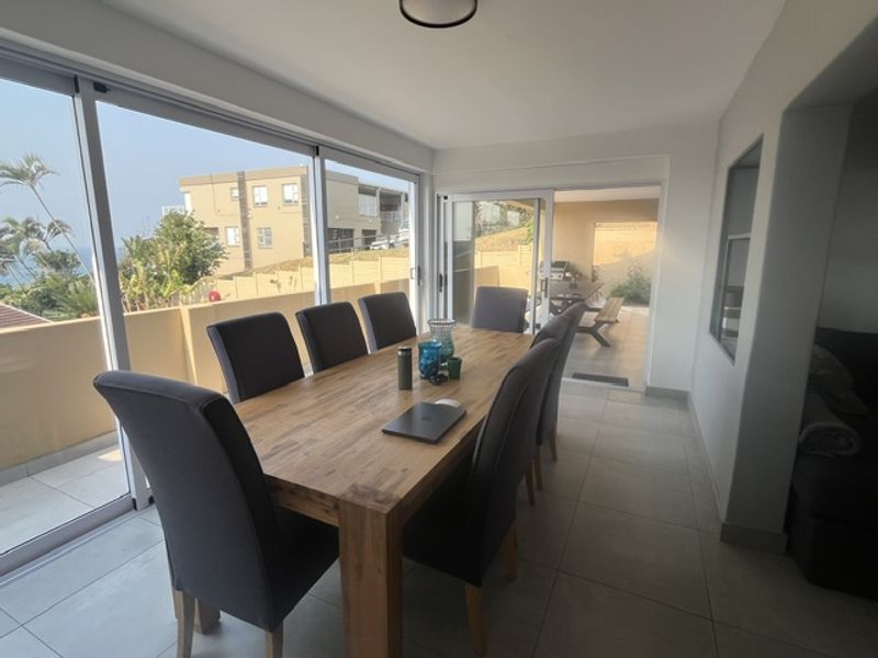 Bright dining area featuring large sliding glass doors that provide seamless access to the outdoor patio and natural light.