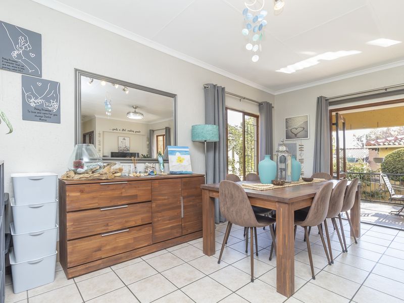 A bright dining room featuring tiled flooring and sliding glass doors that provide direct access to an outdoor patio area.