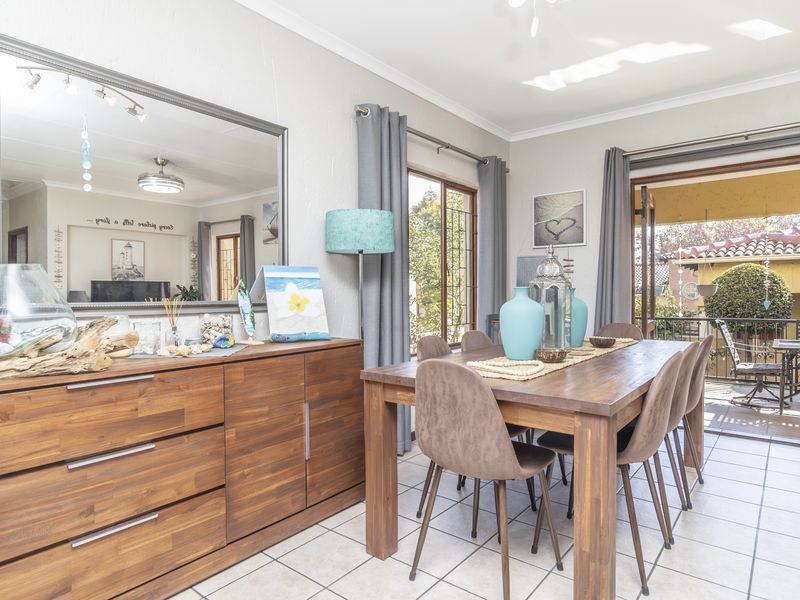 A bright dining room featuring tiled flooring and sliding glass doors that provide direct access to an outdoor patio area.
