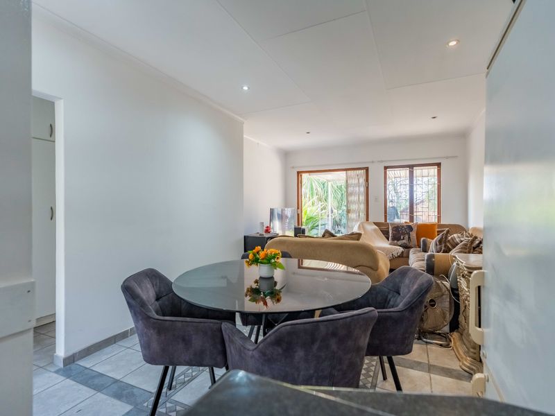Open-plan living and dining area featuring tiled flooring, recessed lighting, and direct access to the outdoor space through a sliding glass door.