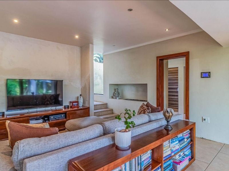 A living room featuring tiled flooring, recessed lighting, and a built-in wall niche, currently showing signs of wall surface wear and peeling paint.
