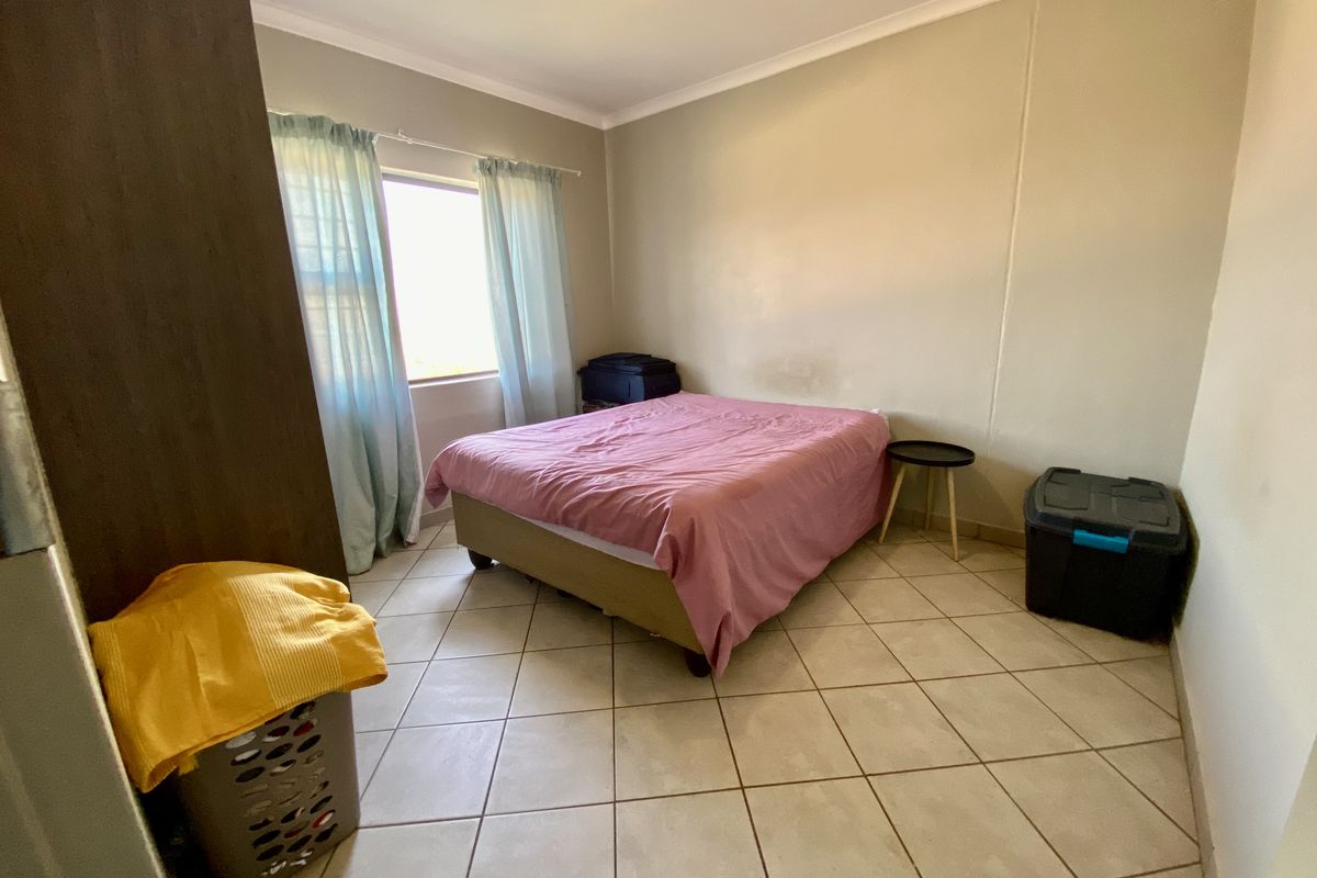A bedroom featuring tiled flooring, built-in cupboard storage, and cove cornicing, requiring minor cosmetic attention to the walls.