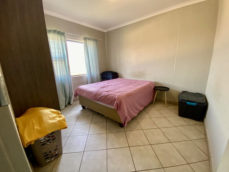 A bedroom featuring tiled flooring, built-in cupboard storage, and cove cornicing, requiring minor cosmetic attention to the walls.
