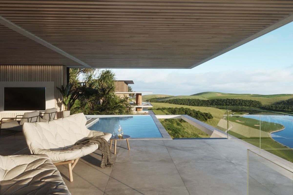 Expansive covered patio featuring a seamless infinity edge pool, glass balustrades, and panoramic views of the surrounding landscape.