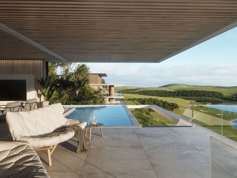 Expansive covered patio featuring a seamless infinity edge pool, glass balustrades, and panoramic views of the surrounding landscape.