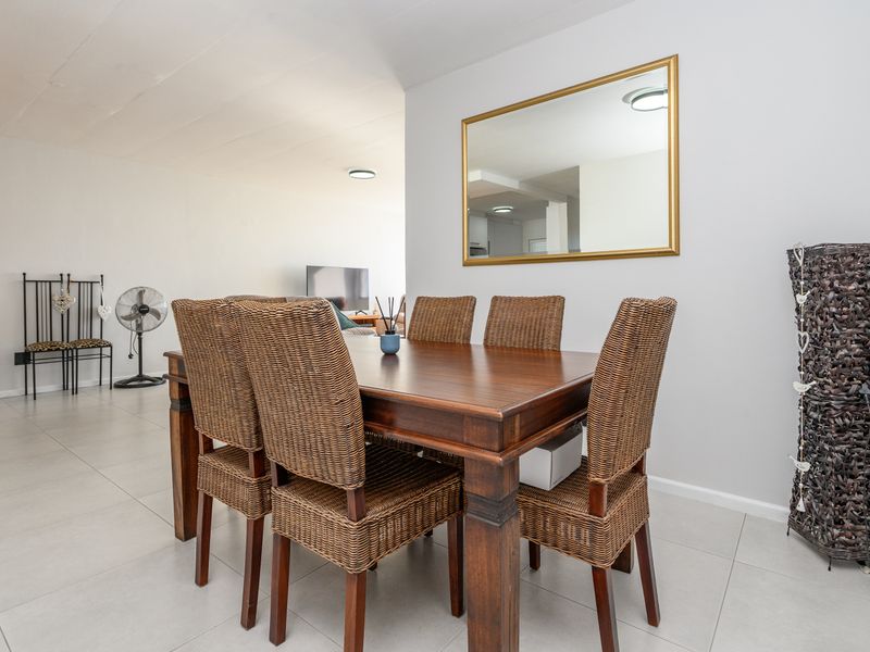 A bright dining area featuring neutral tiled flooring and clean wall finishes, providing an open and functional space for meals.