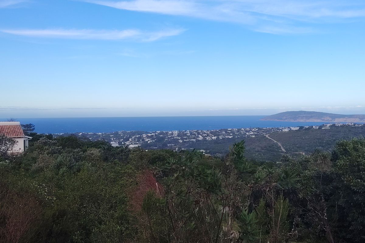 A scenic elevated view overlooking the coastal landscape, residential area, and the ocean horizon.