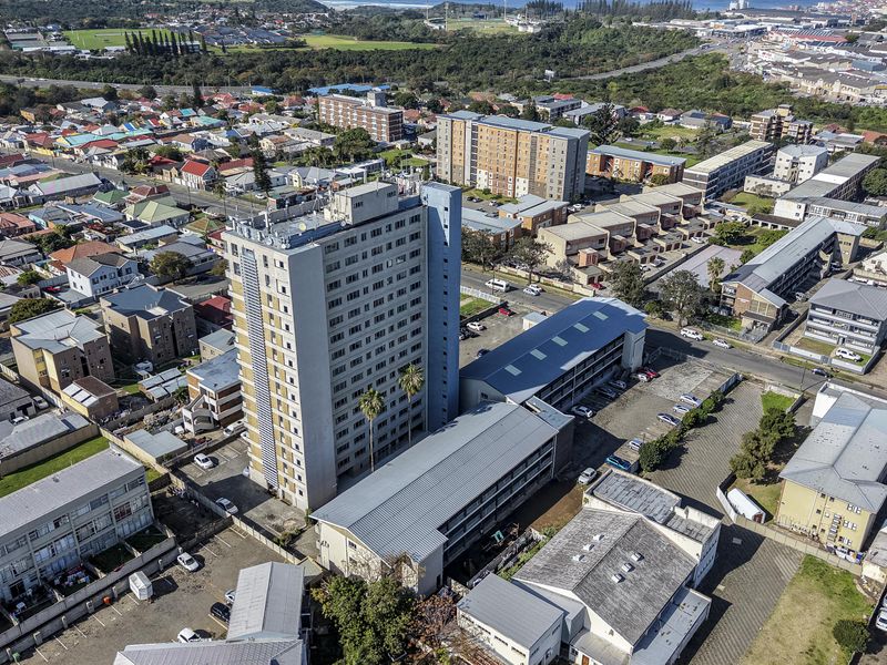 Aerial view of a high-rise apartment complex situated within a dense urban residential neighborhood.
