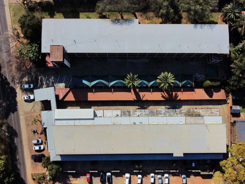 Aerial view of the apartment complex showing multiple building blocks, covered parking facilities, and surrounding grounds.