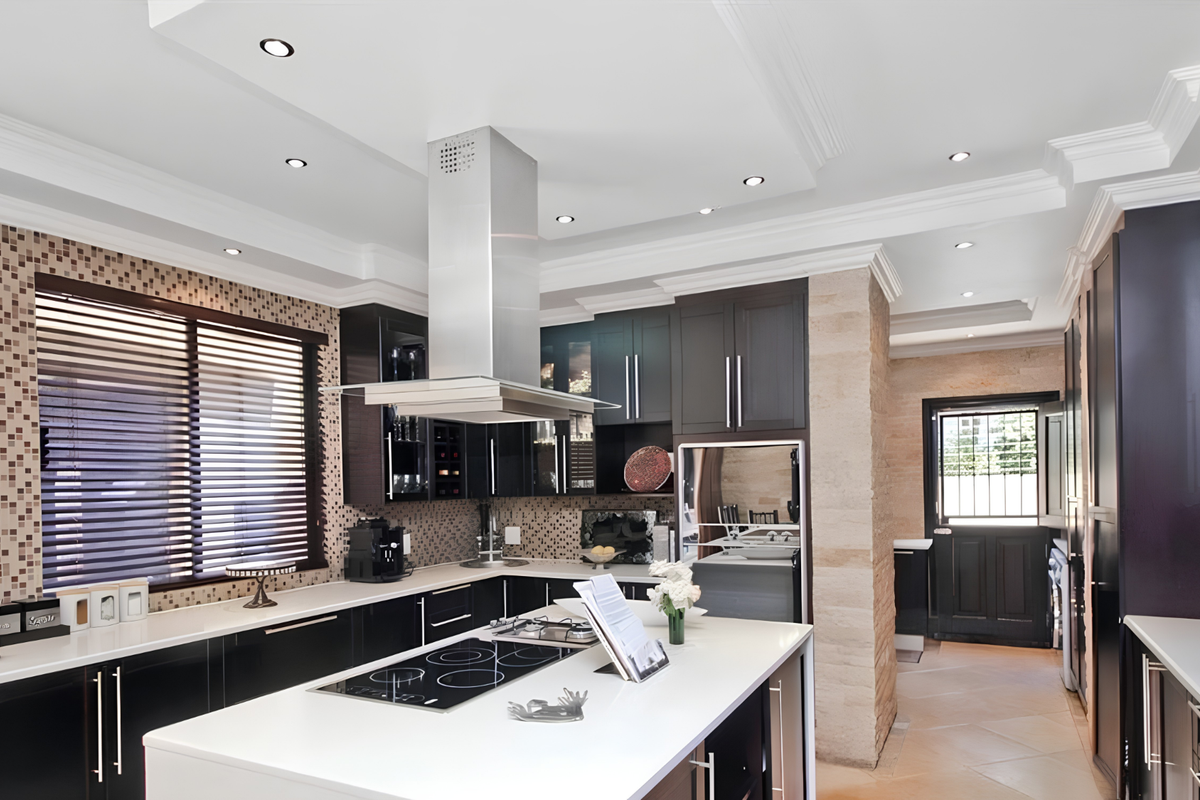 Modern kitchen featuring a central island, sleek dark cabinetry, stone feature wall, mosaic backsplash, and high-end built-in appliances with recessed ceiling lighting.